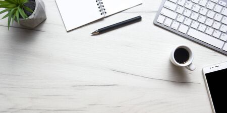 White desk office with laptop, smartphone and other work supplies with cup of coffee. Top view with copy space for input the text. Designer workspace on desk table essential elements on flat lay.の写真素材