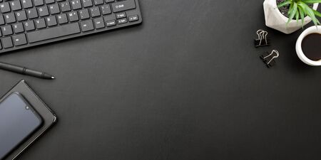 Black desk office with laptop, smartphone and other work supplies with cup of coffee. Top view with copy space for input the text. Designer workspace on desk table essential elements on flat lay.の写真素材