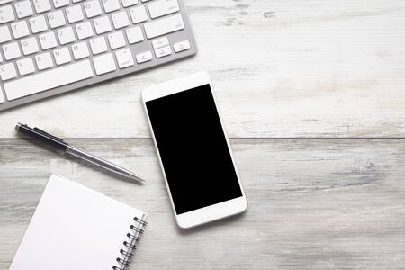 White desk office with laptop, smartphone and other work supplies with cup of coffee. Top view with...