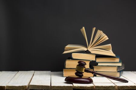 Law concept - Open law book with a wooden judges gavel on table in a courtroom or law enforcement office isolated on white background. Copy space for textの写真素材