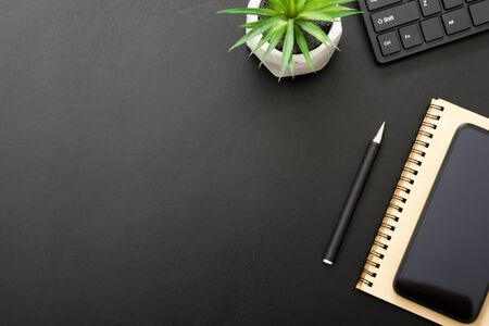 Black desk office with laptop, smartphone and other work supplies with cup of coffee. Top view with copy space for input the text. Designer workspace on desk table essential elements on flat layの写真素材