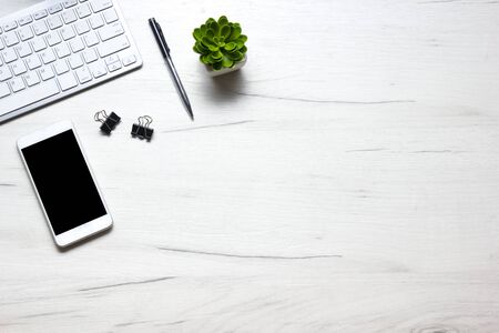White desk office with laptop, smartphone and other work supplies with cup of coffee. Top view with copy space for input the text. Designer workspace on desk table essential elements on flat layの写真素材
