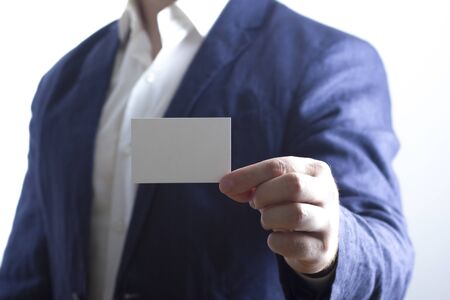 Hand holding white business card on white backgroundの写真素材