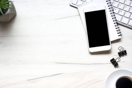 White desk office with laptop, smartphone and other work supplies with cup of coffee. Top view with copy space for input the text. Designer workspace on desk table essential elements on flat layの写真素材