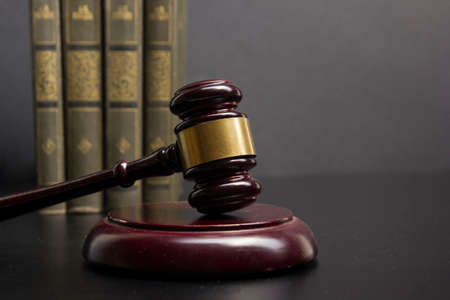 Law concept - Open law book with a wooden judges gavel on table in a courtroom or law enforcement office isolated on white background. Copy space for textの写真素材