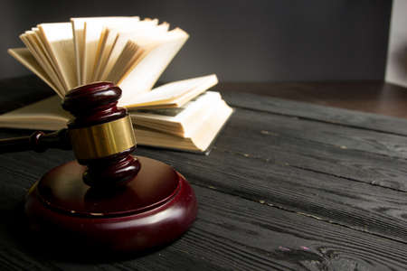 Law concept - Open law book with a wooden judges gavel on table in a courtroom or law enforcement office isolated on white background. Copy space for textの写真素材