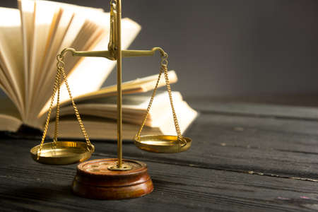 Law concept - Open law book with a wooden judges gavel on table in a courtroom or law enforcement office isolated on white background. Copy space for textの写真素材