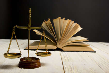 Law concept - Open law book with a wooden judges gavel on table in a courtroom or law enforcement office isolated on white background. Copy space for textの写真素材