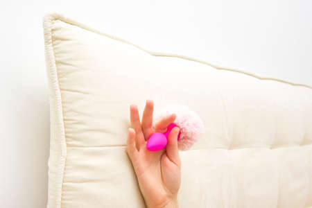 Female in bed holding a vibrator. Sex toy for adultの写真素材