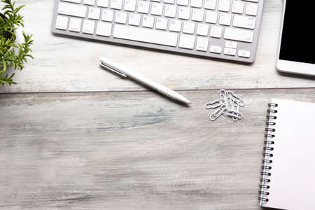 White desk office with laptop, smartphone and other work supplies with cup of coffee. Top view with copy space for input the text. Designer workspace on desk table essential elements on flat layの写真素材