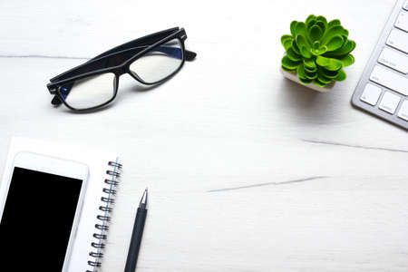 White desk office with laptop, smartphone and other work supplies with cup of coffee. Top view with copy space for input the text. Designer workspace on desk table essential elements on flat layの写真素材