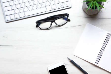White desk office with laptop, smartphone and other work supplies with cup of coffee. Top view with copy space for input the text. Designer workspace on desk table essential elements on flat layの写真素材