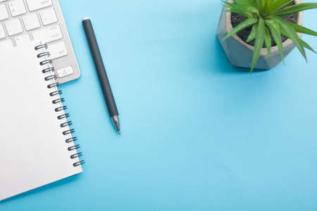 Blue desk office with laptop, smartphone and other work supplies with cup of coffee. Top view with copy space for input the text. Designer workspace on desk table essential elements on flat layの写真素材