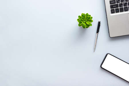 Blue desk office with laptop, smartphone and other work supplies with cup of coffee. Top view with copy space for input the text. Designer workspace on desk table essential elements on flat layの写真素材