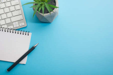 Blue desk office with laptop, smartphone and other work supplies with cup of coffee. Top view with copy space for input the text. Designer workspace on desk table essential elements on flat layの写真素材