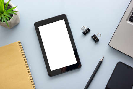 Blue desk office with laptop, smartphone and other work supplies with cup of coffee. Top view with copy space for input the text. Designer workspace on desk table essential elements on flat layの写真素材