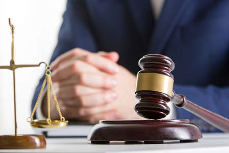 Lawyer working with contract papers and wooden gavel on tabel in courtroom. justice and law...