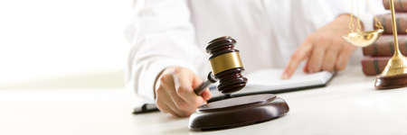 Lawyer working with contract papers and wooden gavel on tabel in courtroom. justice and law...