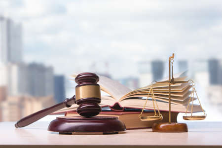 Law concept - Open law book with a wooden judges gavel on table in a courtroom or law enforcement office isolated on white background. Copy space for text.の写真素材