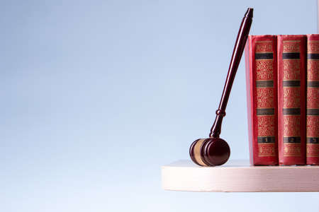 Law concept - Open law book with a wooden judges gavel on table in a courtroom or law enforcement office isolated on white background. Copy space for text.の写真素材
