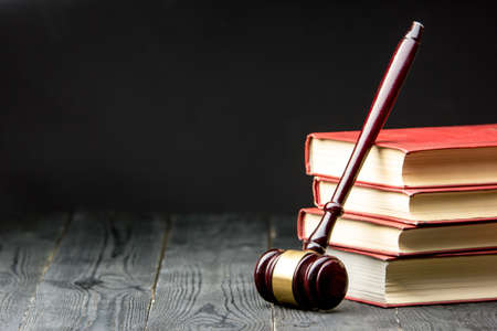 Law concept - Open law book with a wooden judges gavel on table in a courtroom or law enforcement office isolated on white background. Copy space for text.の写真素材