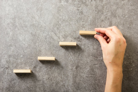 Plan and strategy in business, Risk To Make Business Growth Concept With Wooden Blocks, hand of man has piling up and stacking a wooden blockの写真素材