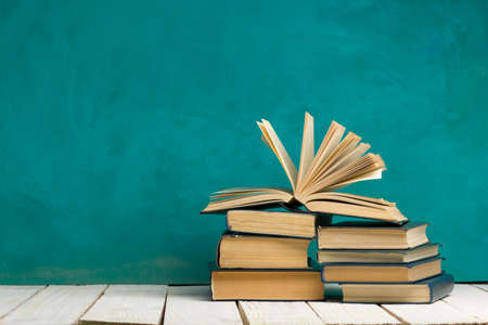 Open book, hardback books on wooden table. Back to school. Copy space.の写真素材