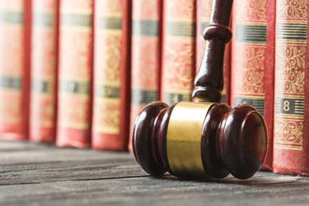 Law concept - Open law book with a wooden judges gavel on table in a courtroom or law enforcement office isolated on white background. Copy space for textの写真素材