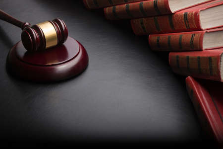 Law concept - Open law book with a wooden judges gavel on table in a courtroom or law enforcement office isolated on white background. Copy space for textの写真素材