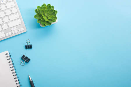 Blue desk office with laptop, smartphone and other work supplies with cup of coffee. Top view with copy space for input the text. Designer workspace on desk table essential elements on flat lay.の写真素材