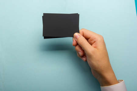 Hand holding white business card on abstract backgroundの写真素材