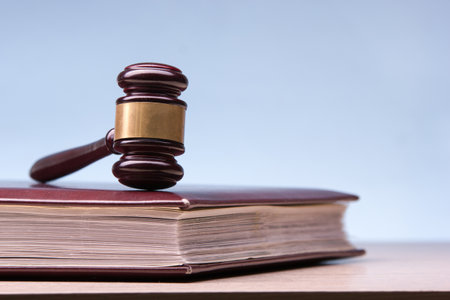 Law concept - Open law book with a wooden judges gavel on table in a courtroom or law enforcement office isolated on white background. Copy space for textの写真素材