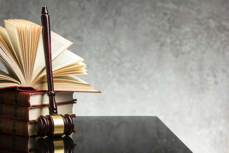 Law concept - Open law book with a wooden judges gavel on table in a courtroom or law enforcement office isolated on white background. Copy space for textの写真素材