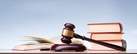 Law concept - Open law book with a wooden judges gavel on table in a courtroom or law enforcement office isolated on white background. Copy space for textの写真素材