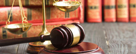 Law concept - Open law book with a wooden judges gavel on table in a courtroom or law enforcement office isolated on white background. Copy space for textの写真素材