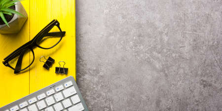 Yellow desk office with laptop, smartphone and other work supplies with cup of coffee. Top view with copy space for input the text. Designer workspace on desk table essential elements on flat lay.の写真素材