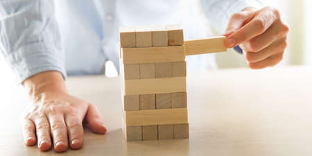 Plan and strategy in business, Risk To Make Business Growth Concept With Wooden Blocks, hand of man has piling up and stacking a wooden blockの写真素材