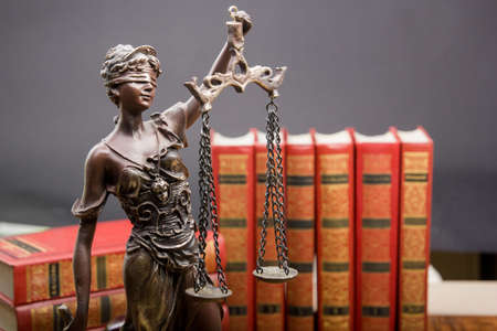 Legal Law and Justice concept - Open law book with a wooden judges gavel on table in a courtroom or...