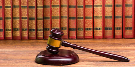 Legal Law and Justice concept - Open law book with a wooden judges gavel on table in a courtroom or law enforcement office. Copy space for textの写真素材
