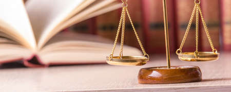 Legal Law and Justice concept - Open law book with a wooden judges gavel on table in a courtroom or...