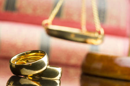 Divorce and separation concept. Two golden wedding rings and judge gavel.の写真素材