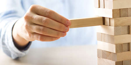Plan and strategy in business, Risk To Make Business Growth Concept With Wooden Blocks, hand of man has piling up and stacking a wooden blockの写真素材