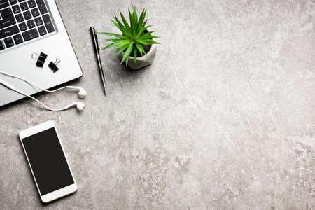 White desk office with laptop, smartphone and other work supplies with cup of coffee. Top view with...