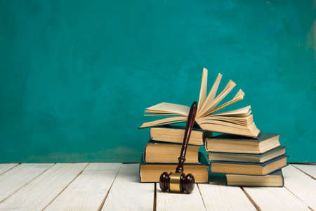 Legal Law and Justice concept - Open law book with a wooden judges gavel on table in a courtroom or law enforcement office. Copy space for textの写真素材