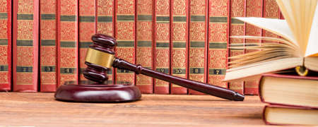 Legal Law and Justice concept - Open law book with a wooden judges gavel on table in a courtroom or law enforcement office. Copy space for textの写真素材