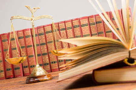 Legal Law and Justice concept - Open law book with a wooden judges gavel on table in a courtroom or law enforcement office. Copy space for textの写真素材