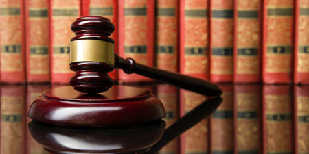 Legal Law and Justice concept - Open law book with a wooden judges gavel on table in a courtroom or law enforcement office. Copy space for textの写真素材