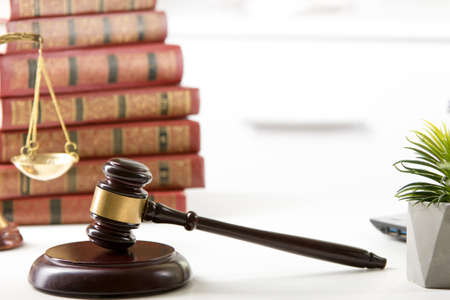 Legal Law and Justice concept - Open law book with a wooden judges gavel on table in a courtroom or law enforcement office. Copy space for textの写真素材