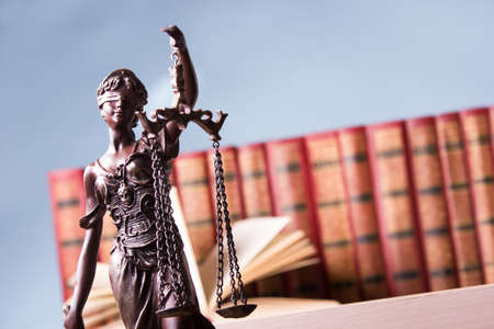 Legal Law and Justice concept - Open law book with a wooden judges gavel on table in a courtroom or...