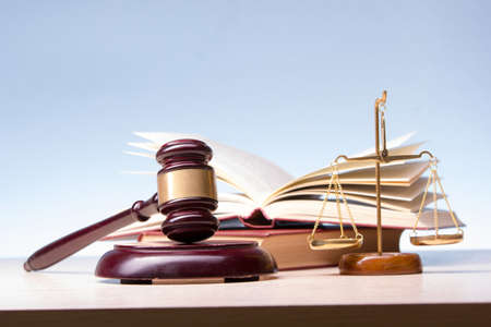 Legal Law and Justice concept - Open law book with a wooden judges gavel on table in a courtroom or law enforcement office. Copy space for text.の写真素材